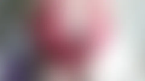 Bekleidet mit rotem Dessous, schwarzen Strapsen und roten Seidenhandschuhen