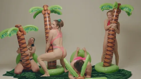 4 girls with inflatable palm trees